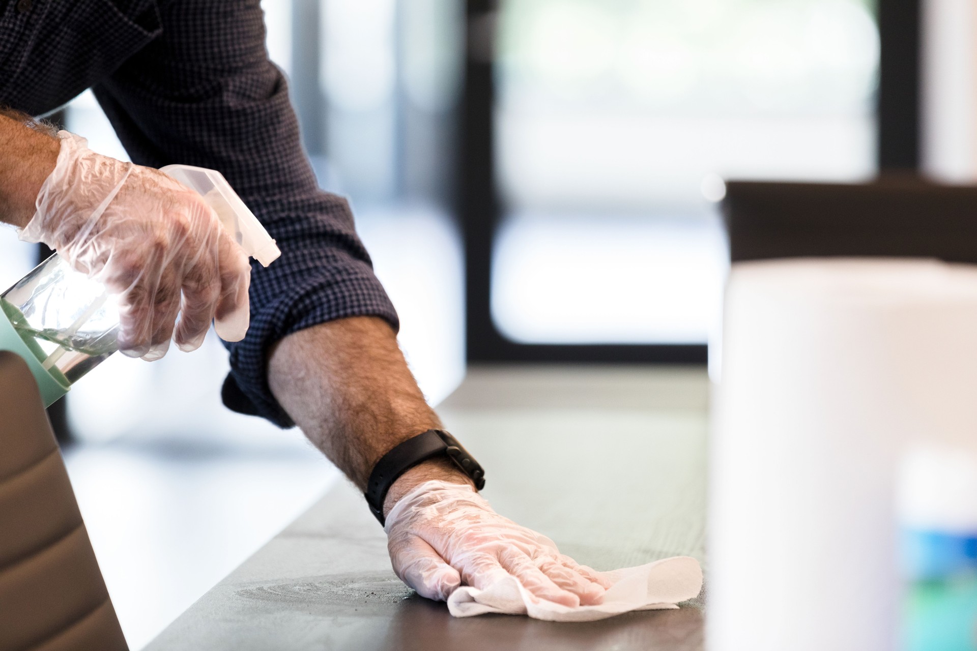 Janitor pulvérise le produit de nettoyage sur la table